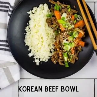 keto Korean Beef Bowl on a black plate with a side of cauliflower rice.
