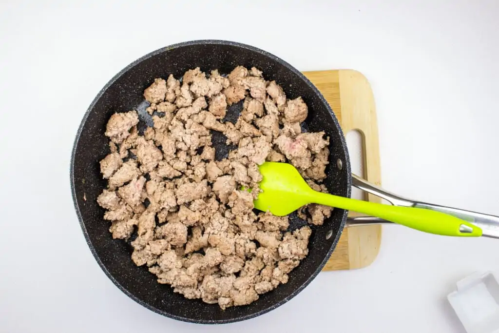 browning the ground pork in a large black skillet