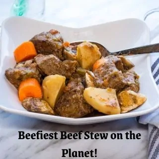 beefiest beef stew on the planet in a bowl with a spoon