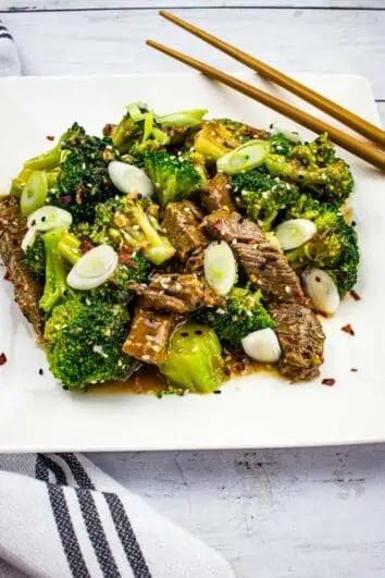 keto beef and broccoli on a square plate with chopsticks