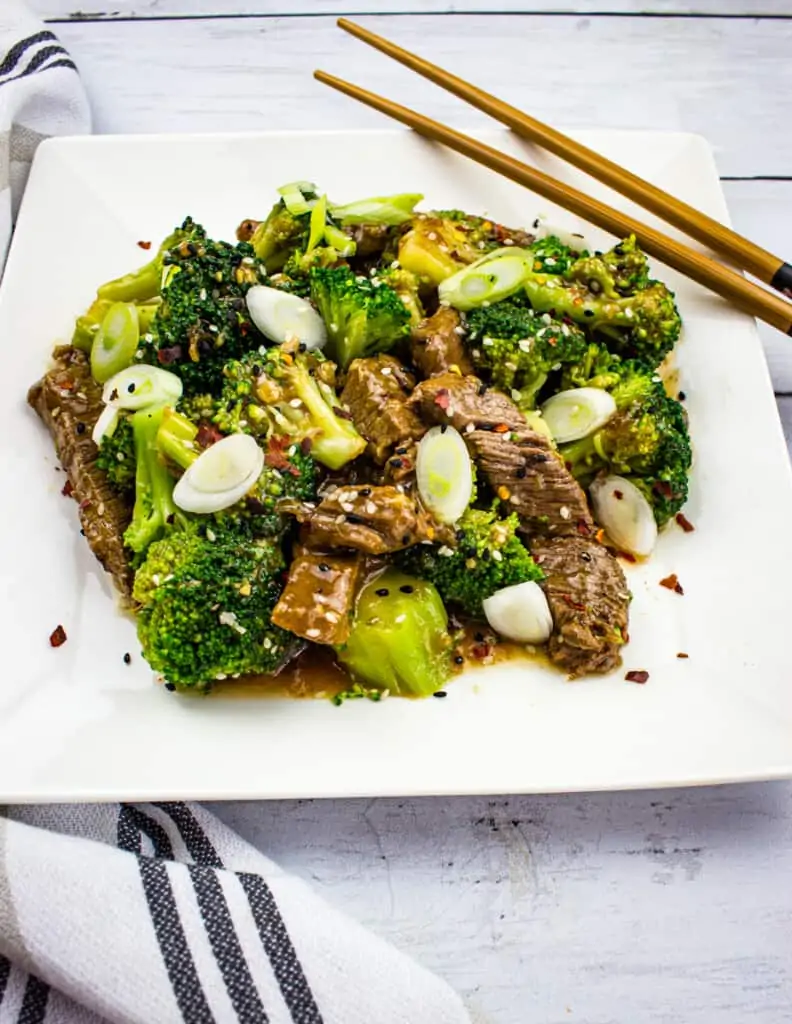 keto beef and broccoli on a square plate with chopsticks
