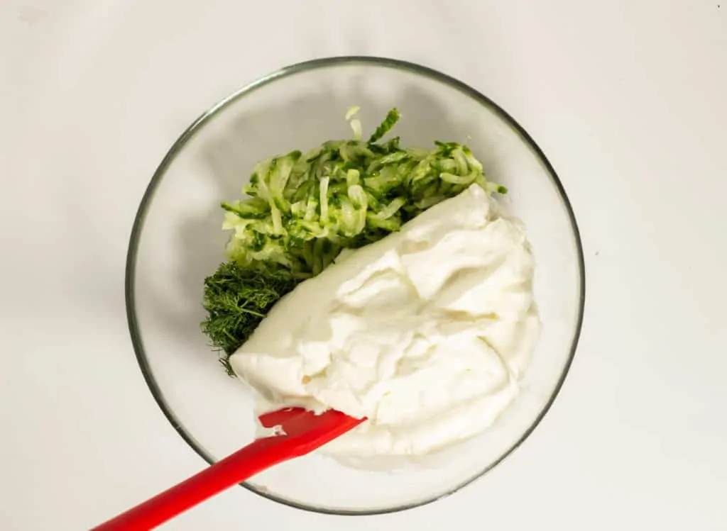 Dill, cucumber, Greek yogurt in a mixing bowl.