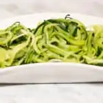 Zucchini noodles in a white dish.