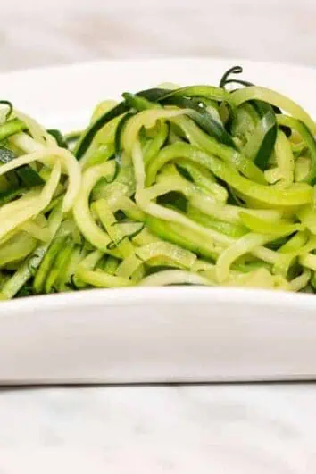 Zucchini noodles in a white dish.