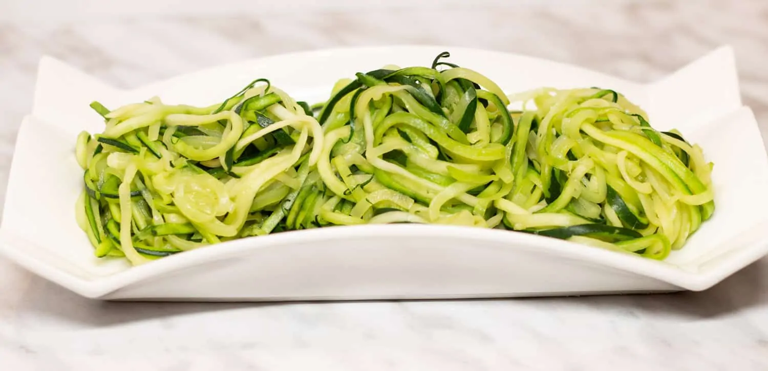 Zucchini noodles in a white dish.