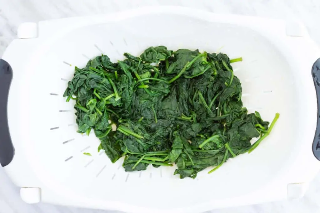 satueed spinach in a collander