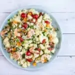 A colorful salad with shrimp, cauliflower and veggies in a lemon dressing