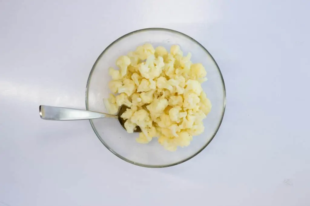 blanched cauliflower in a bowl with spoon
