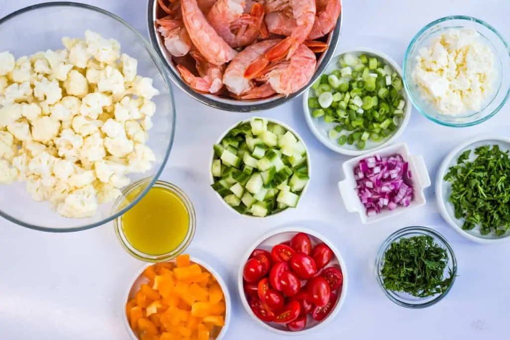 shrimp, cauliflower, tomatoes, dill, bell pepper, cucumber, feta ready to turn into a salad