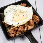 keto corned beef hash on a plate with an egg on top