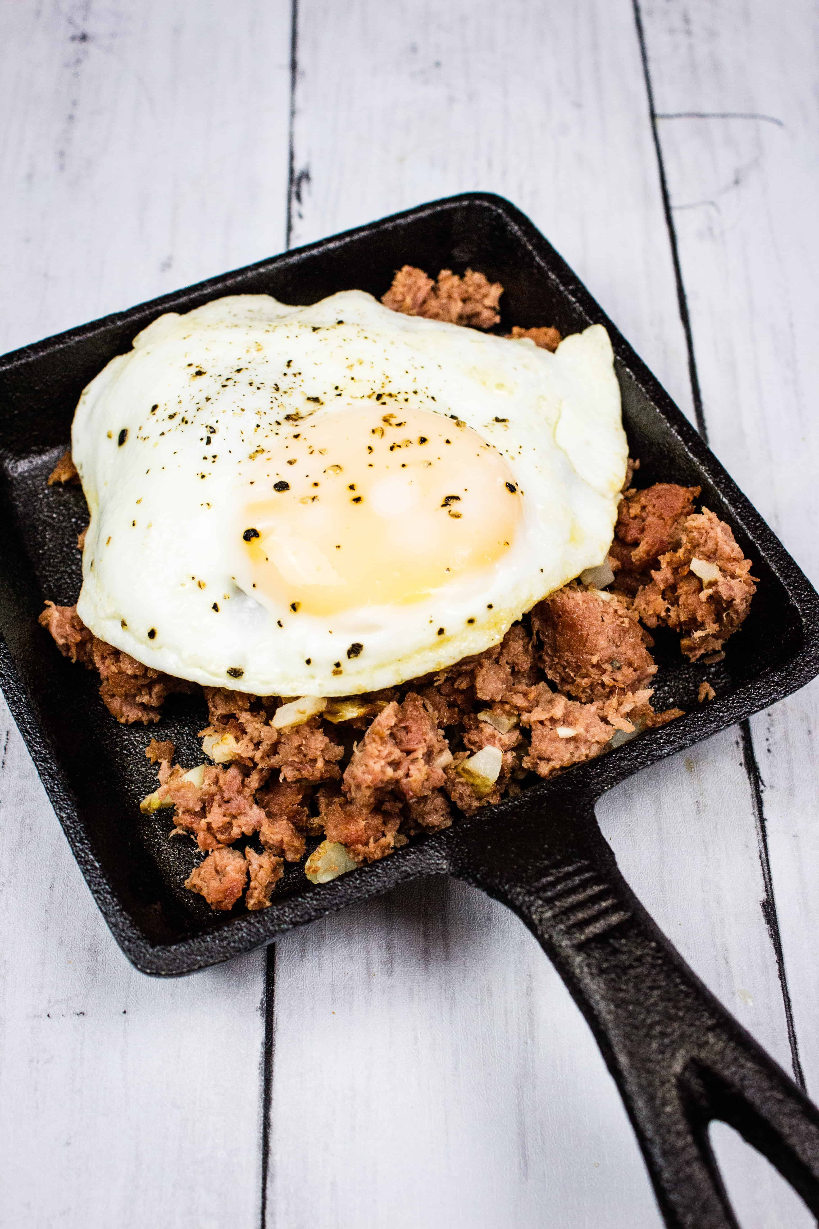 keto corned beef hash on a plate with an egg on top