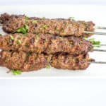 Five skewers of grilled Low-Carb/Keto Kefta Beef Kabobs on a white plate