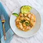 keto and low carb chicken taco casserole on a plate with lime and fanned avocado