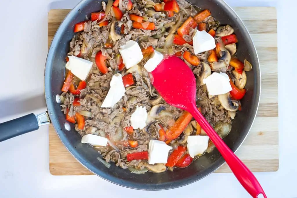 broth and cream cheese added to skillet with beef, mushrooms, onions, and ppepers