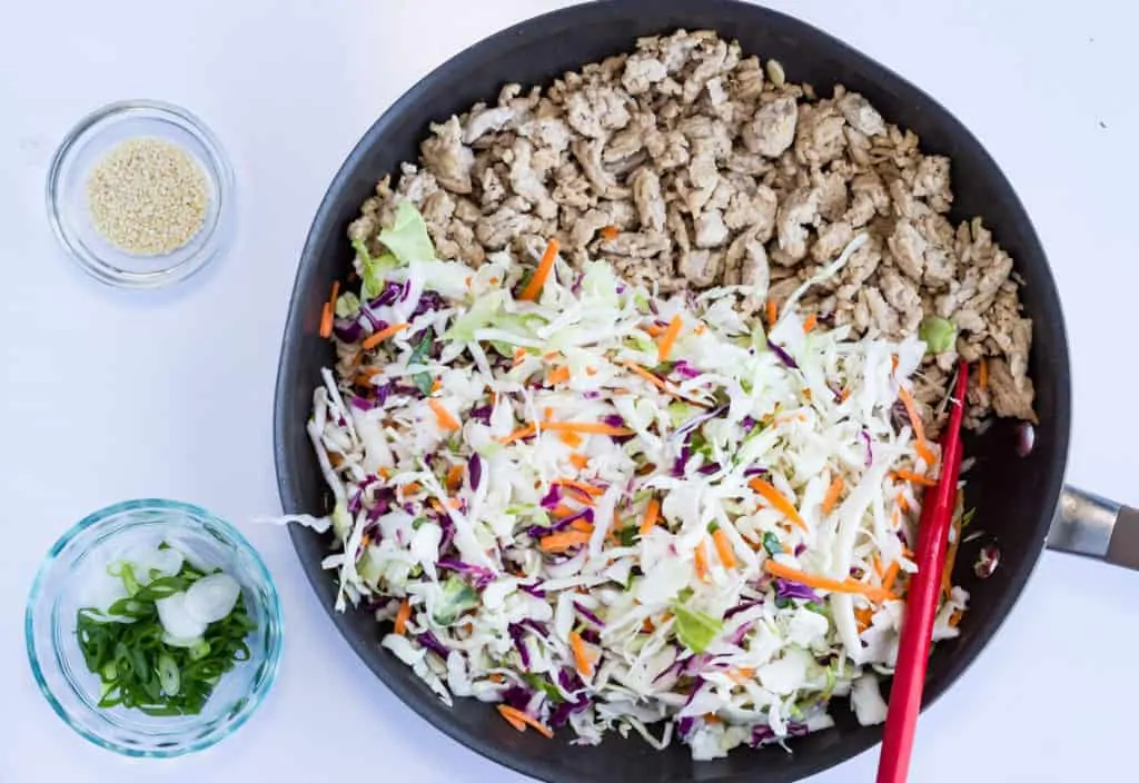 Keto Egg Roll in a Bowl cabbage and cooked pork in a skillet