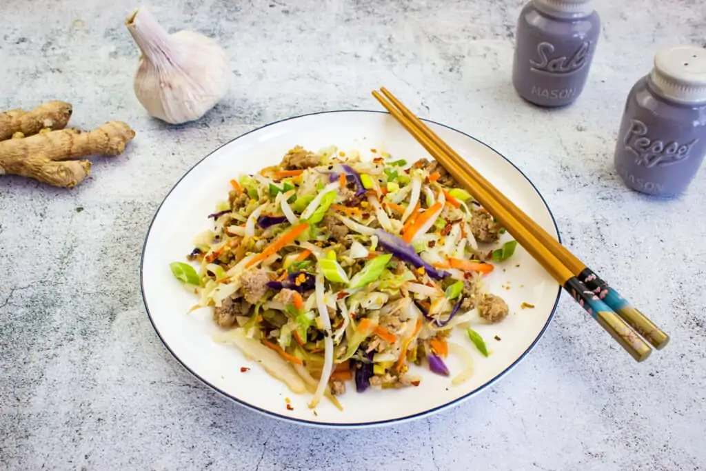 keto egg roll in a bowl on a plate with chopsticks