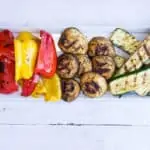 Keto Grilled Veggies with grilled red and yellow peppers, mushrooms, and zucchini on a platter.