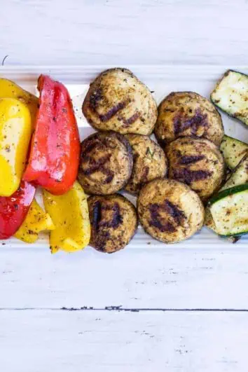 Keto Grilled Veggies with grilled red and yellow peppers, mushrooms, and zucchini on a platter.