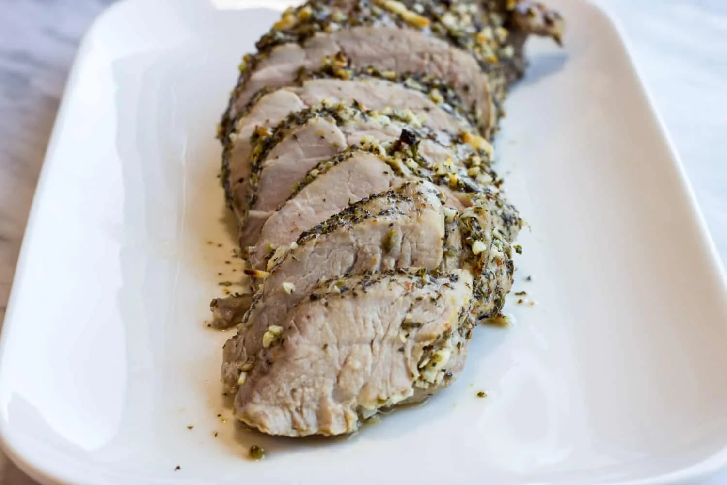 Garlic & Herb Roasted Pork Tenderloin slice on a platter.