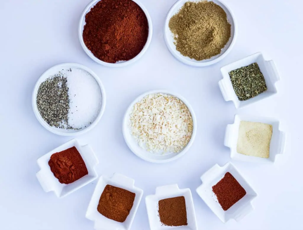 A rainbow of ingredients in small dishes to make keto taco seasoning.