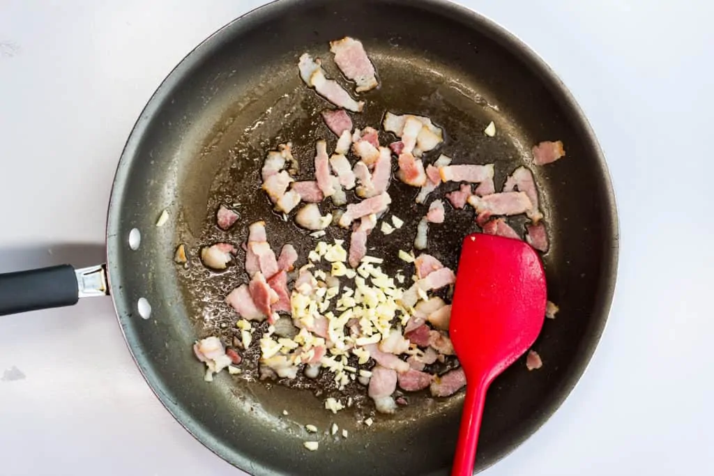 Sizzling bacon and onion in a pan