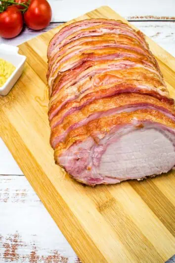 smoked bacon wrapped pork loin on a cutting board