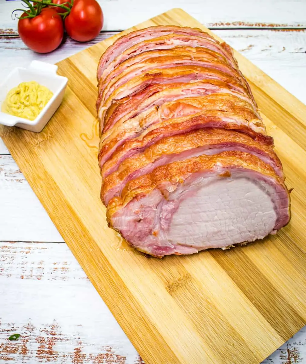 smoked bacon wrapped pork loin on a cutting board
