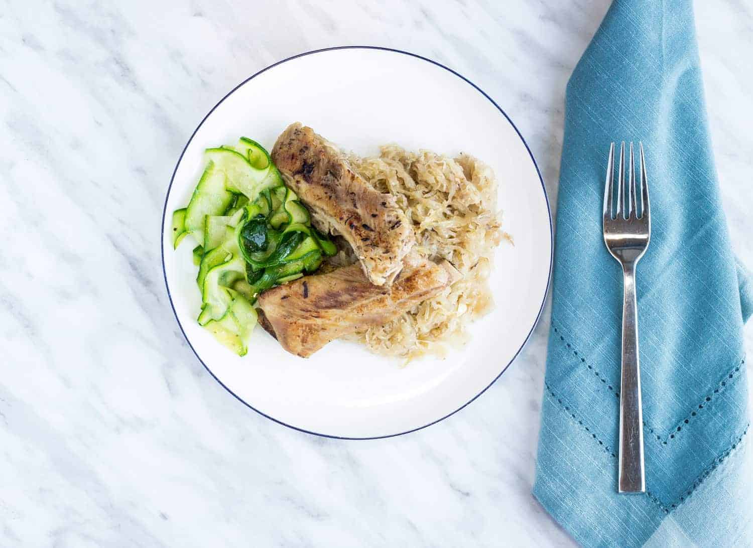 meaty ribs and sauerkraut on a plate with zucchini noodles