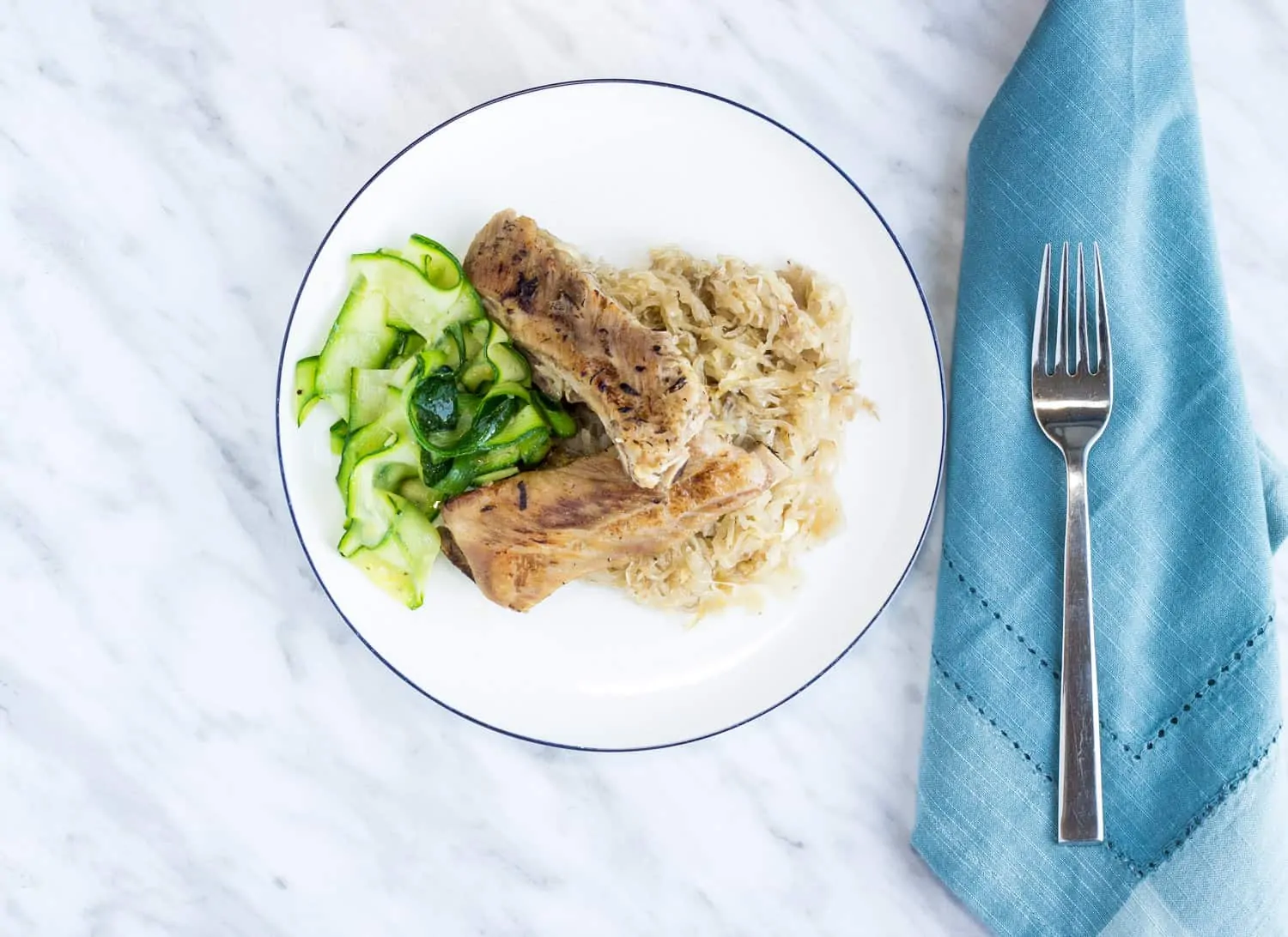 meaty ribs and sauerkraut on a plate with zucchini noodles