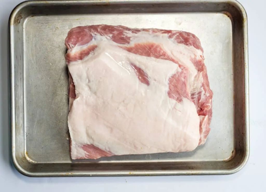 Naked pork loin on a sheet pan.
