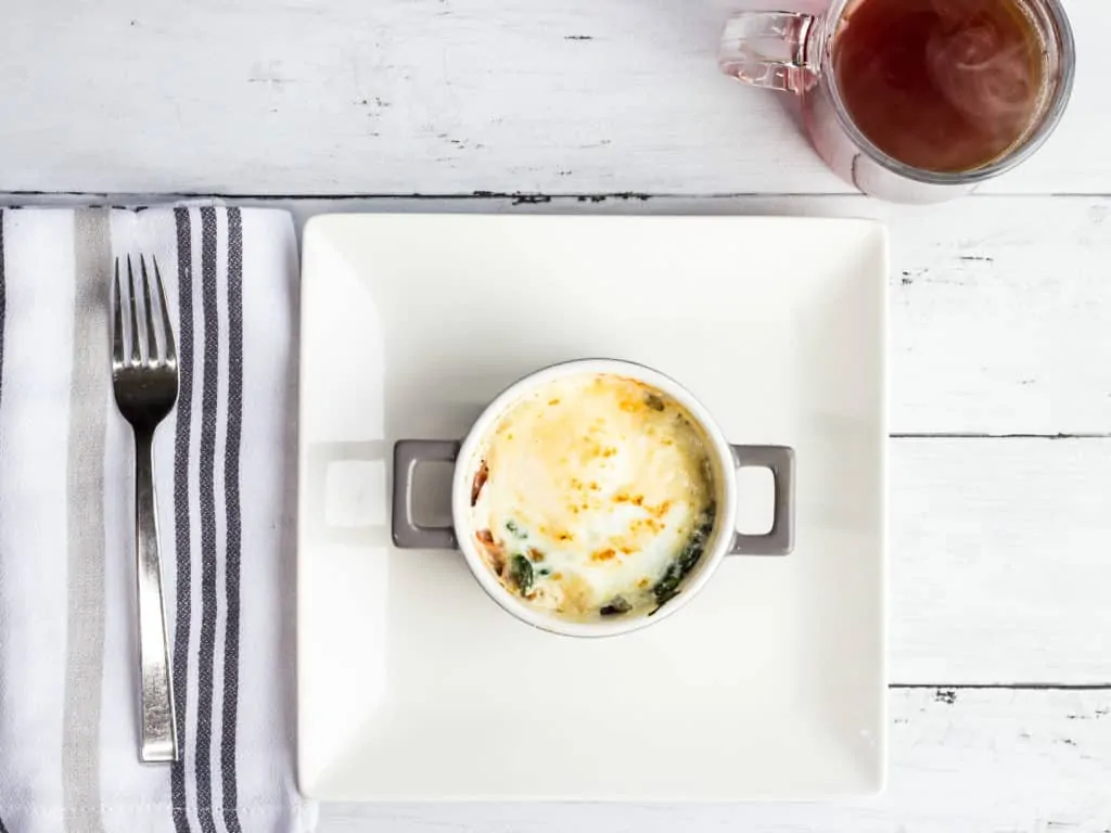 Baked Eggs Florentine with Ham served on plate.