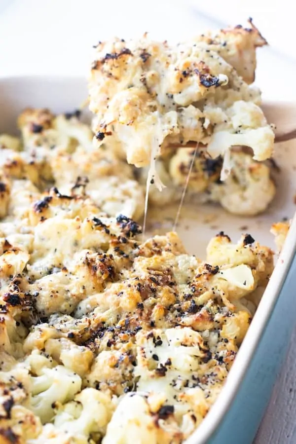 A serving spoon scooping up a portion of Everything Bagel Cauliflower Casserole.