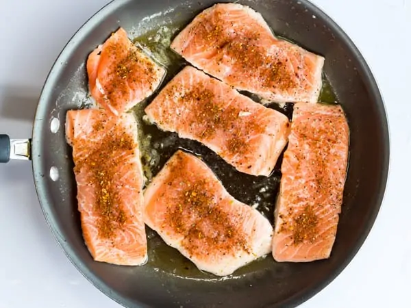 salmon fillets in pan seasoned