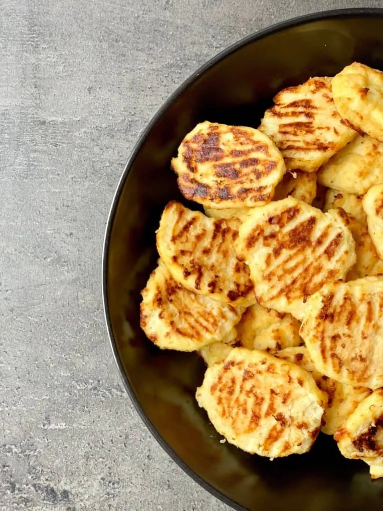 The left half of a round black bowl filled with Pan-browned Cauliflower Gnocchi.