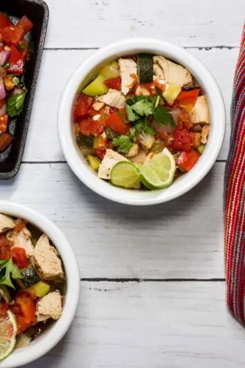 Two bowls of Mexican Turkey Soup with a side of salsa.