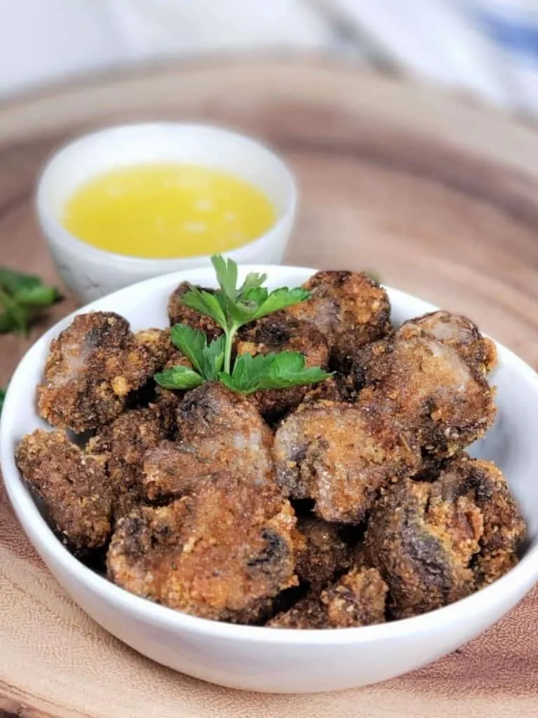 A bowl of Air Fryer Garlic Mushrooms with a garnish of parsley.