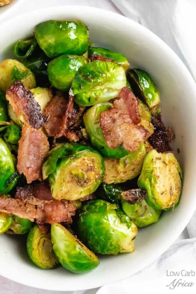 Closeup of Stir Fried Brussels Sprouts with Bacon in a white bowl.