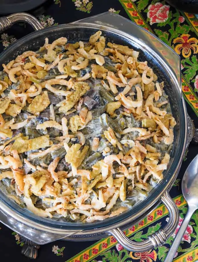 Keto Green Bean Casserole in a round silver serving dish with a spoon.