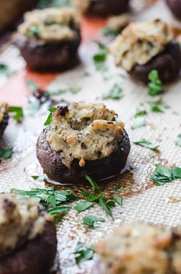 Closeup of a cooked pesto stuffed mushroom on a non-stick baking mat.