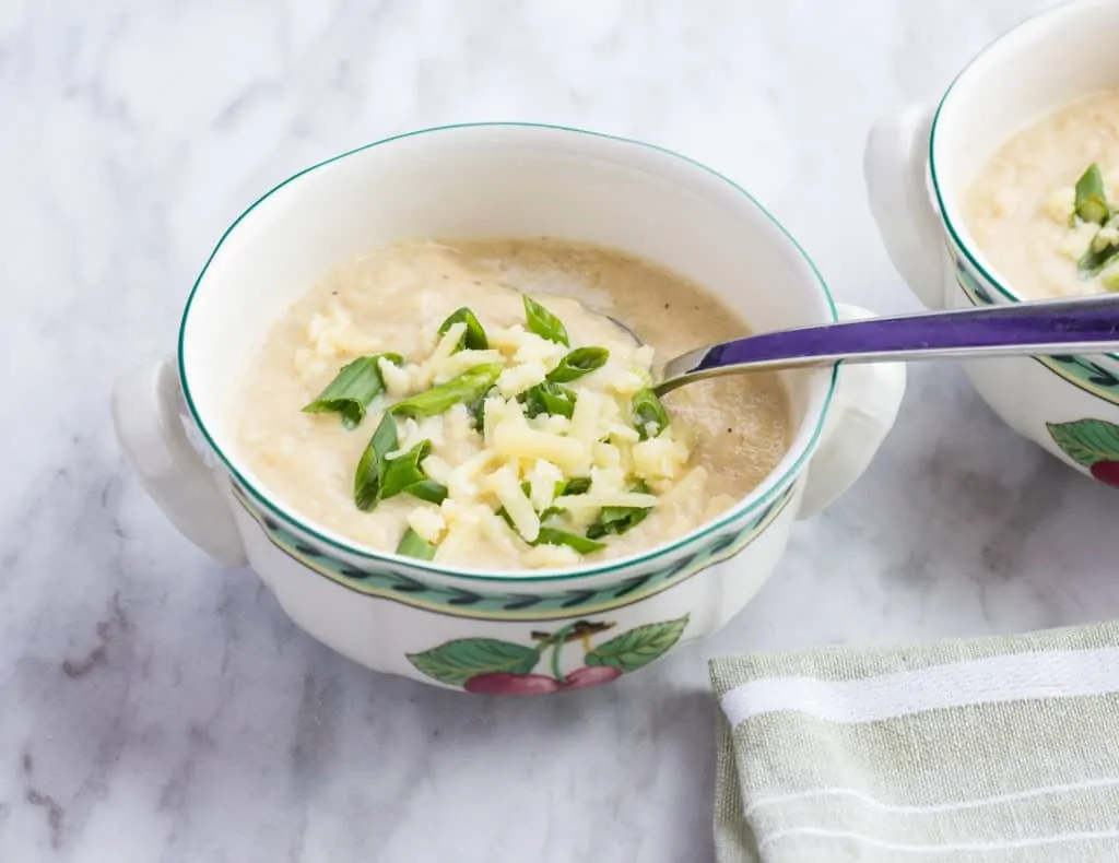 keto roasted cauliflower soup in a bowl with a spoon