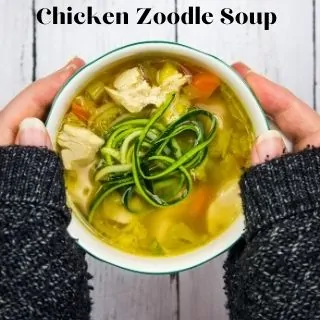 keto chicken zoodle soup in a bowl held between two hands