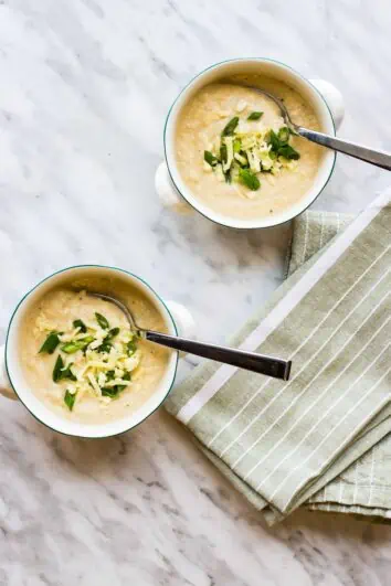 keto cauliflower soup in two bowls with spoons