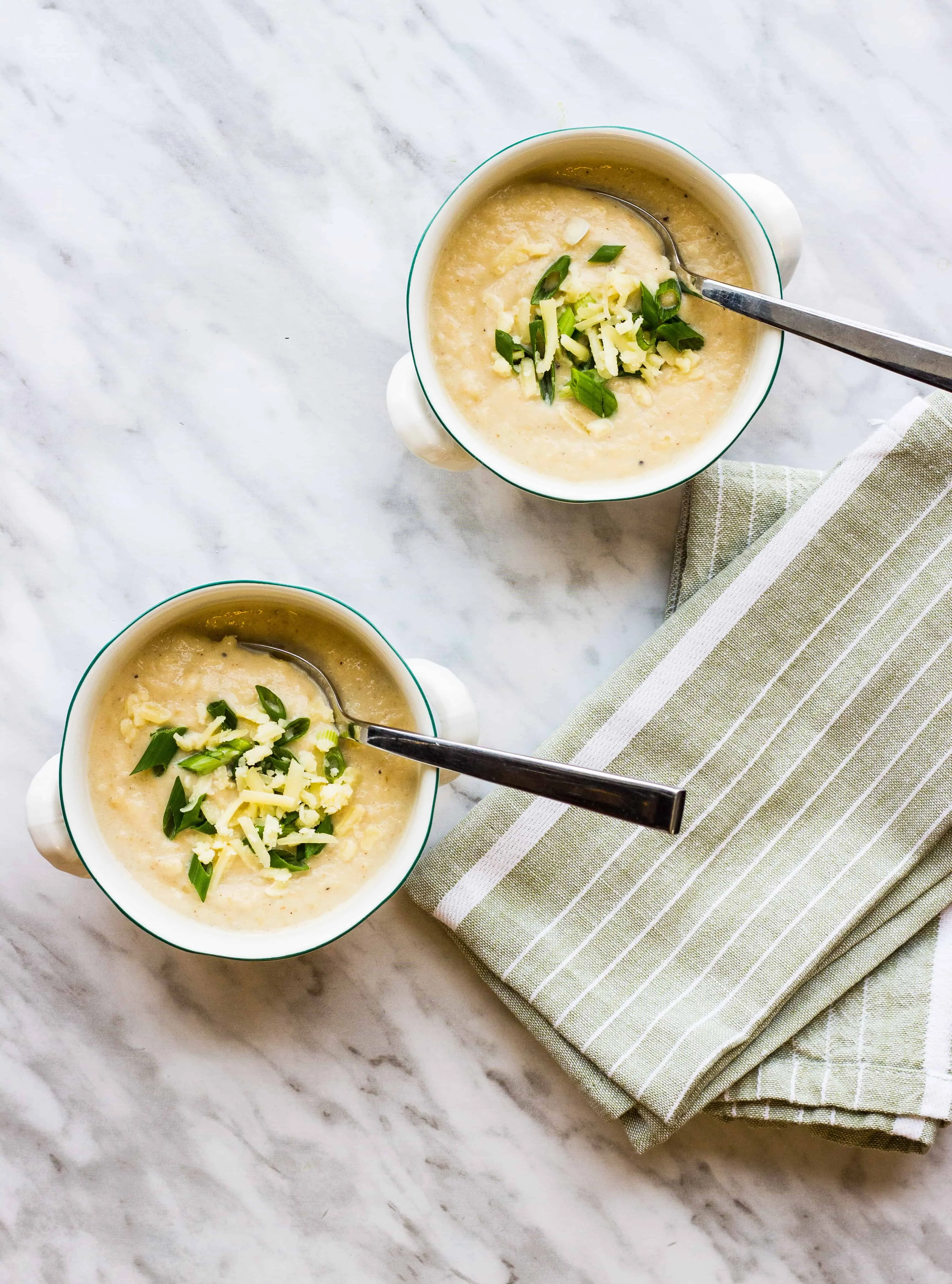 keto cauliflower soup in two bowls with spoons