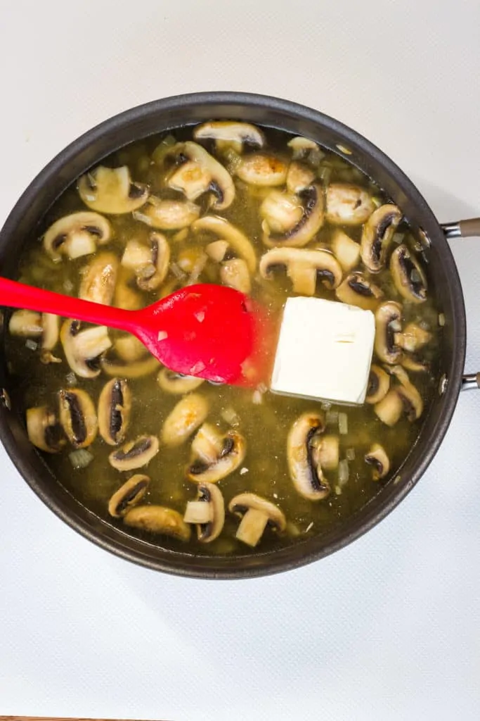 making the sauce with cream cheese and chicken stock