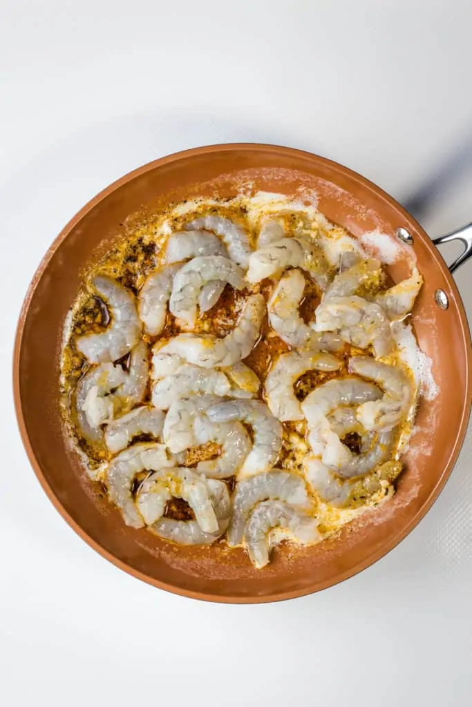 cooking the shrimp, butter, and seasoning in a skillet