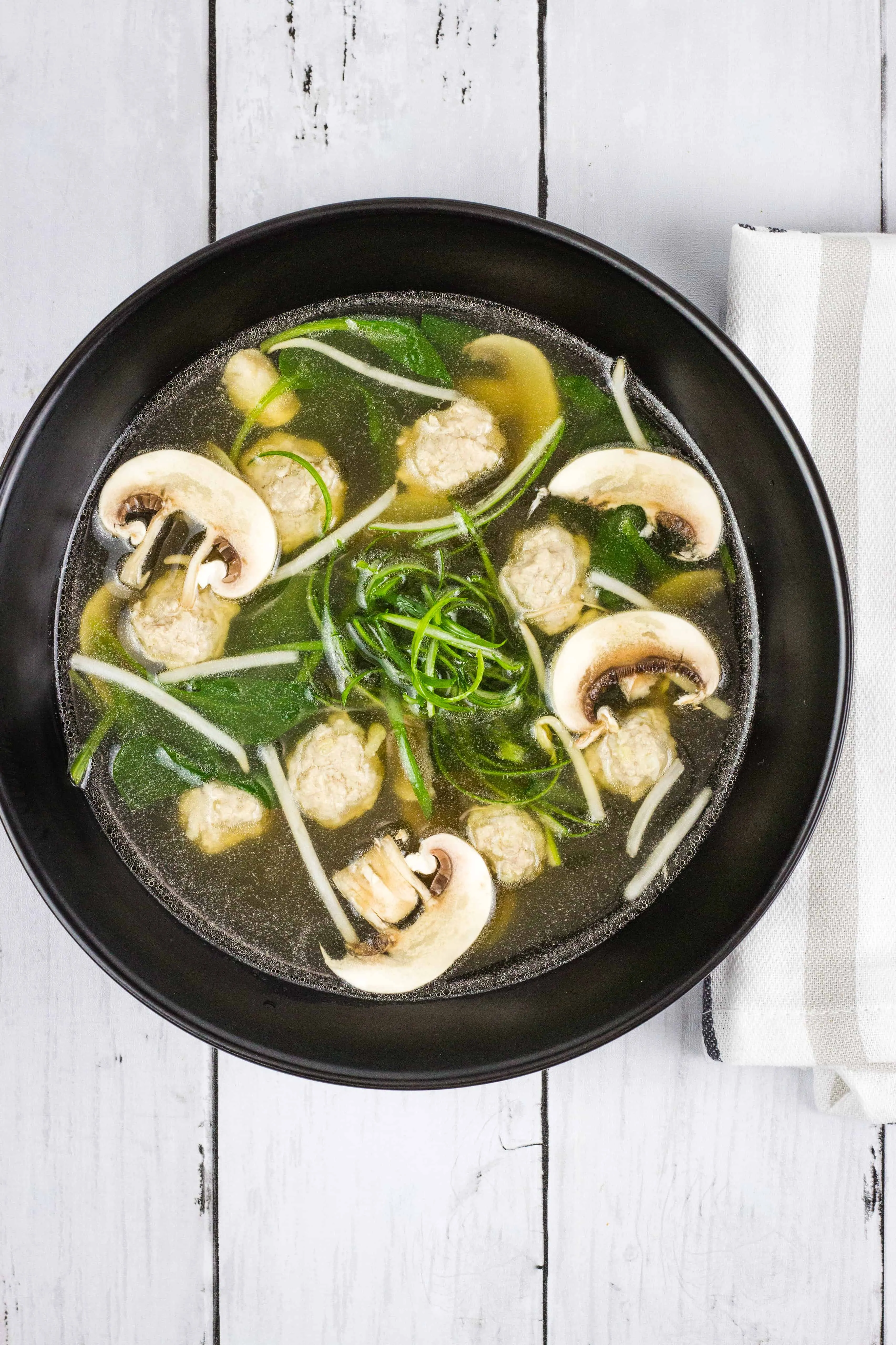 Keto Wonton Soup in a black bowl.