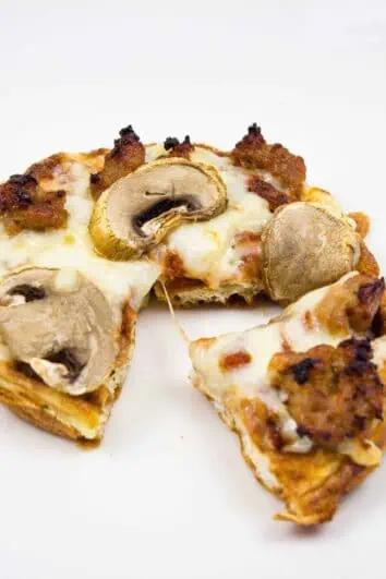 chaffle pizza topped with mushroom and sausage