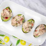 Four pieces of avocado filled with Mediterranean tuna salad.