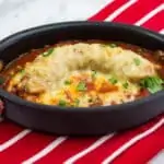 A single serving of sausage parmigiana in a baking dish