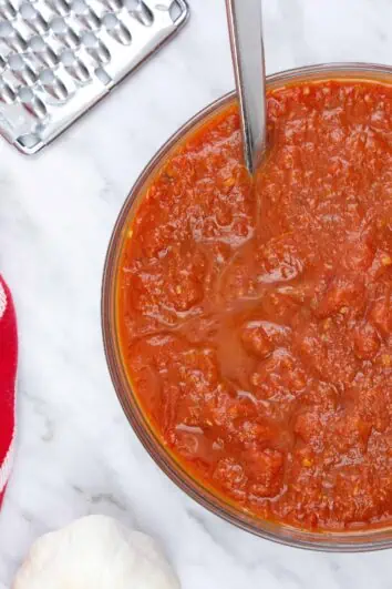 oven roasted tomato sauce in a bowl with parmesan nearby